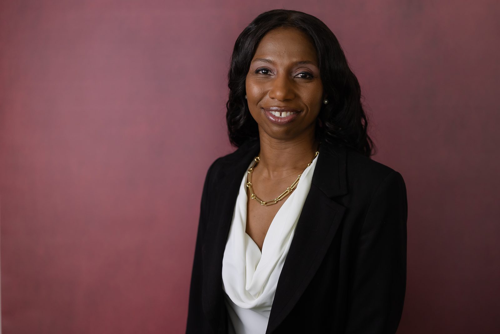 Executive headshot on burgundy backdrop