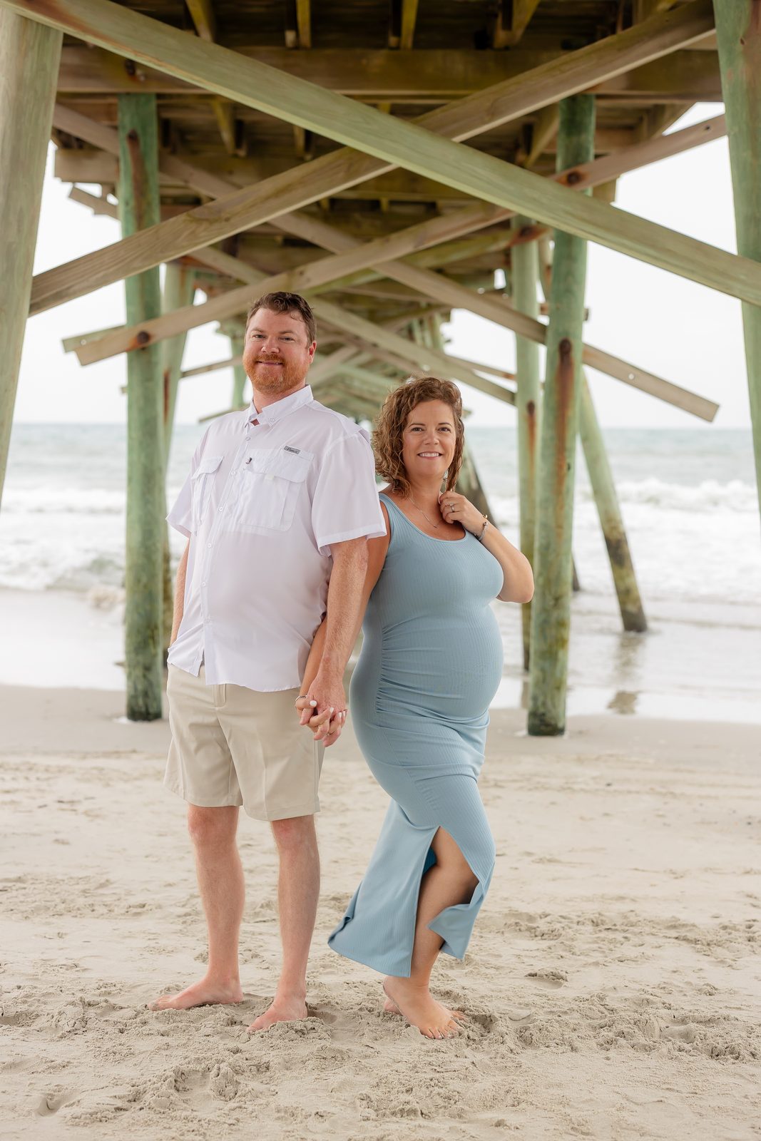 Maternity couple at beach in blue and white