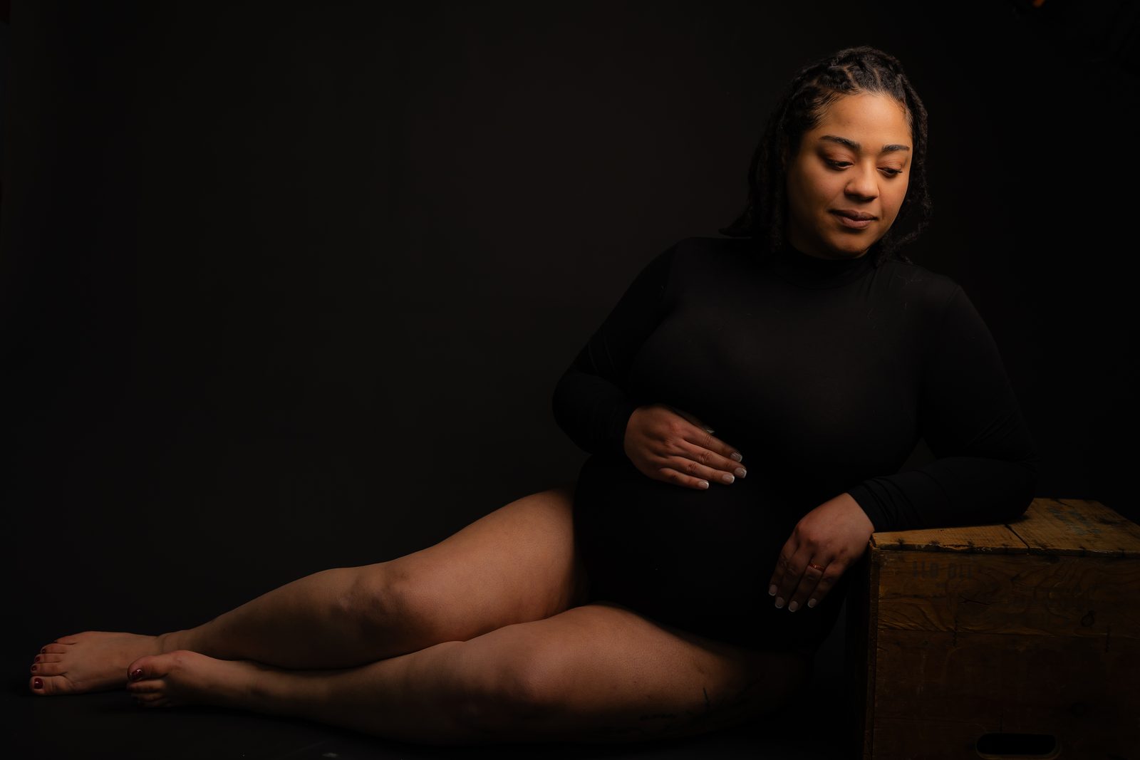 Maternity portrait in dark studio setting