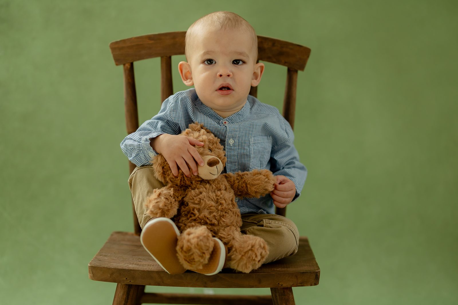 Baby with teddy bear on sage backdrop