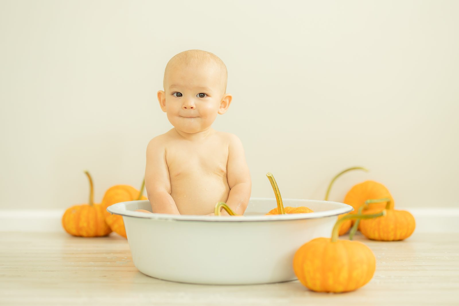 Baby in tub with pumpkins around